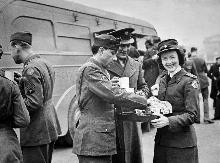 Framed Print : A Red Cross worker smiles as she offers American soldiers candy and cigarettes after the 'Wings for Victory' week celebration in London, England, March 1943