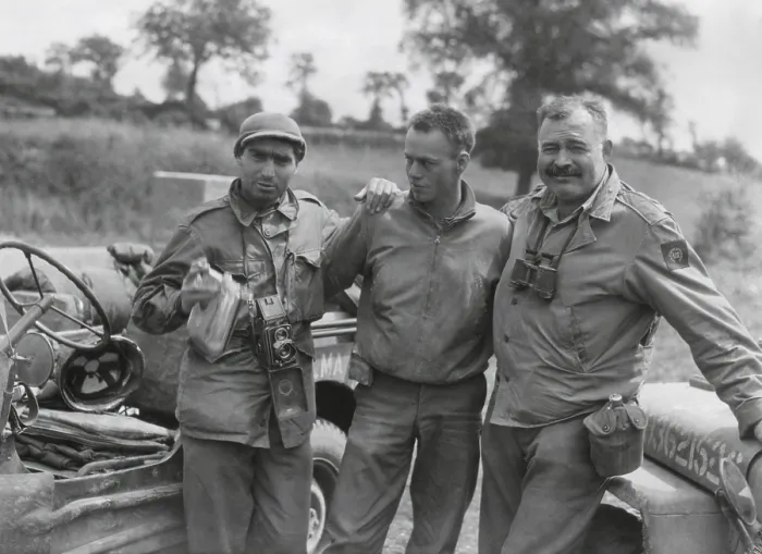 Framed Print : Robert Capa (left) and Ernest Hemingway (right) with their driver U.S. Army driver. They are waiting to follow an American Armored unit into action near Mont Bocard, France