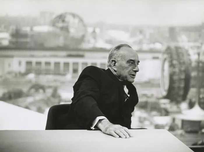 Framed Print : Robert Moses in 1964, seated at a table with a view of the New York Worlds Fair in the distance