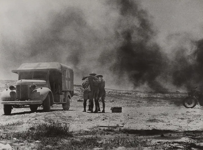 Framed Print : Royal Army Medical Corps ambulance convoy under attack in the Western Desert, Egypt. Two soldiers assist a wounded driver who escaped his blazing vehicle. Ca. 1940-42 Framed Print : Royal Army Medical Corps ambulance convoy under attack in the Western Desert, Egypt. Two soldiers assist a wounded driver who escaped his blazing vehicle. Ca. 1940-42