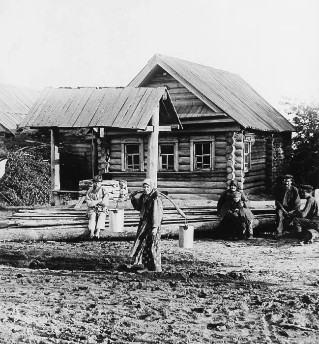 Framed Print : A Russian peasant women carries two pails of water with the aid of a shoulder yoke, ca. 1920. She trudges through mud with felt boots, like those worn by Russia soldiers in WW1