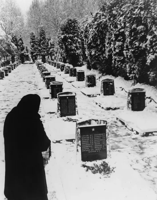 Framed Print : Russian woman in a snow-covered military cemetery. World War 2 Soviet tombstones are inscribed with several names. Unknown location. 1945 photo by Yevgeny Khaldei
