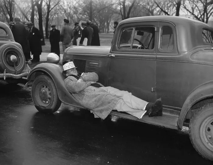 Framed Print : Seamen protest against the Copeland Safety-At-Sea Act. Jan. 18, 1937. One striker takes a nap on an auto running board as his mates protest. (BSLOC_2013_6_116)