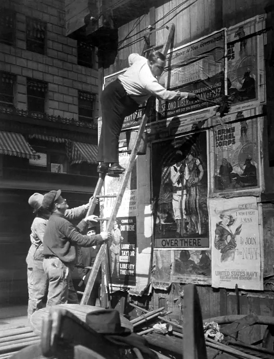 Framed Print : Second Liberty Loan Campaign during World War I. Movie star Fattie Arbuckle, balanced on a ladder, putting up a Liberty Loan poster at Times Square, New York. Oct. 1917