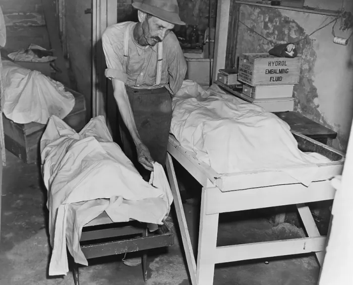 Framed Print : Sheet covered bodies of four lynched African Americans in a Georgia morgue. The coroner places a sheet over the body of one of four