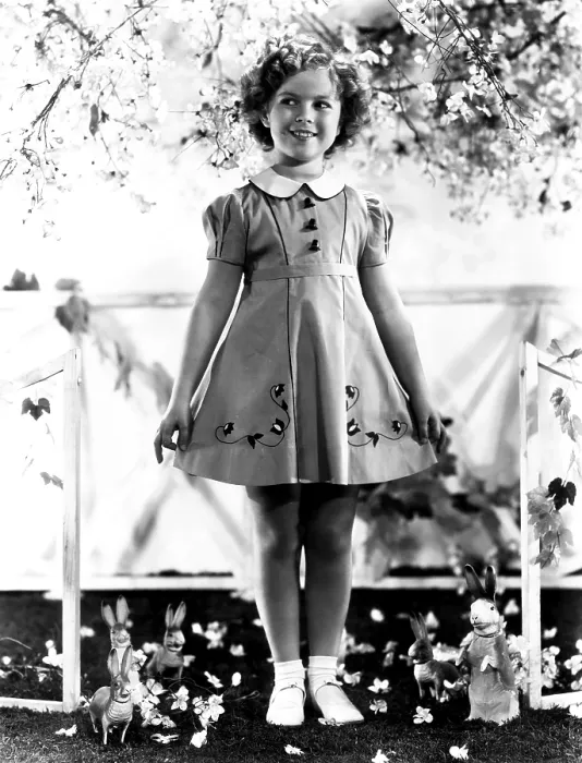 Framed Print : Shirley Temple, modeling a spring frock of shantung with hat-shaped buttons, ca. 1936
