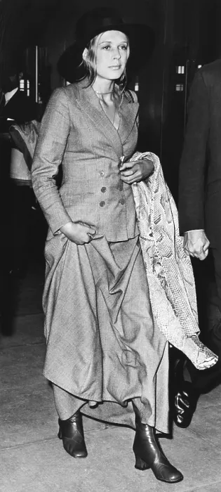 Framed Print : Singer Marianne Faithful at Heathrow Airport after arriving from Dublin, June 26, 1970. She wears a newly fashionable menswear suit with a maxi skirt and a snake skin coat