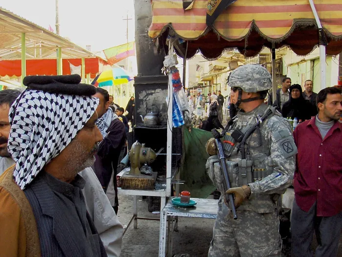 Framed Print : US soldier patrols the streets of Martyrs Market as local nationals shop in Mahmudiyah Iraq a Sunni Iraqi city south of Baghdad which was a center of insurgency during Framed Print : US soldier patrols the streets of Martyrs Market as local nationals shop in Mahmudiyah Iraq a Sunni Iraqi city south of Baghdad which was a center of insurgency during