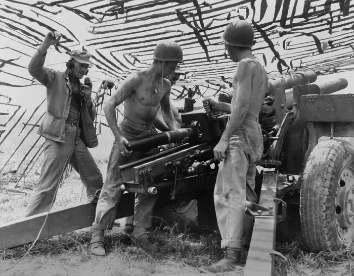 Framed Print : Four soldiers man U.S. Army 105 mm. artillery under a camouflage net in South Korea in the second month of the Korean War. U.S