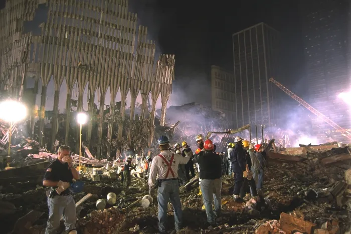 Framed Print : On the south west area of Ground Zero a bucket line removes debris at night, Sept 17, 2001. At left a section of WTC 1, the North Tower still stands
