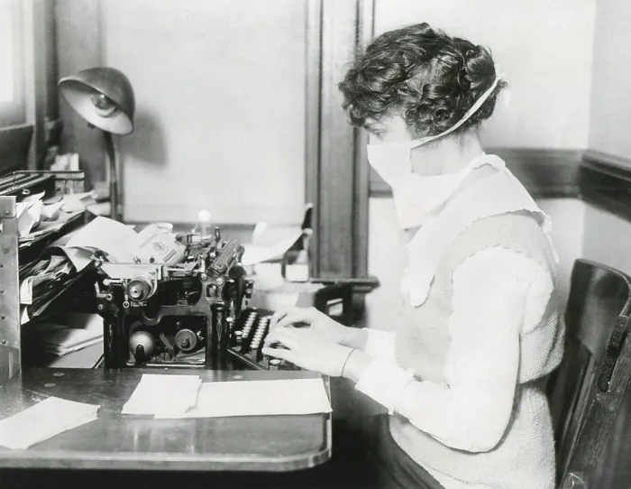 Framed Print : Spanish Flu Epidemic 1918-1919 in America. Wearing a gauze surgical mask while working, this typist protects herself against influenza. New York City, Oct