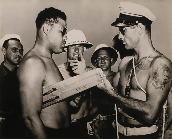 Framed Print : Staff Sergeant Joe Louis, world champion heavyweight, is instructed in the use of a lifebelt while touring bases during World War II