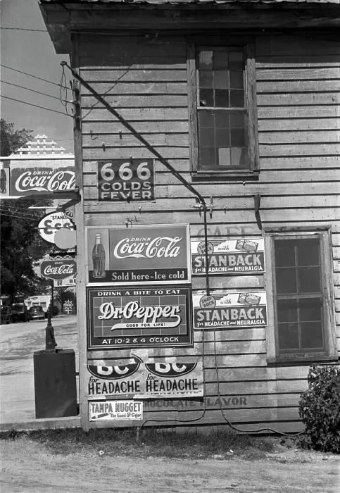 Framed Print : Side of a store, showing advertising signs, including 666 cold medicine, Dr. Pepper, Coca-Cola, Esso Gasoline, Halifax, North Carolina, photograph by John Vachon, April, 1938