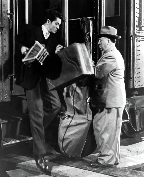 Framed Print : STRANGERS ON A TRAIN, director ALFRED HITCHCOCK makes a cameo appearance, oblivious to FARLEY GRANGER, 1951