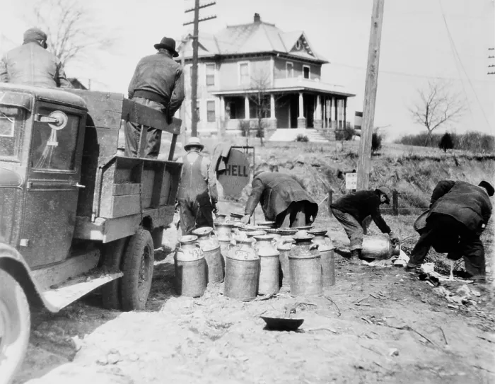 Framed Print : Striking farmers dump milk cans from a truck they have stopped to prevent delivery to market during the Great Depression