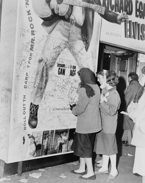 Framed Print : Teenage girls add graffitti to LOVE ME TENDER movie poster, Elvis Presley's film debut. 1956