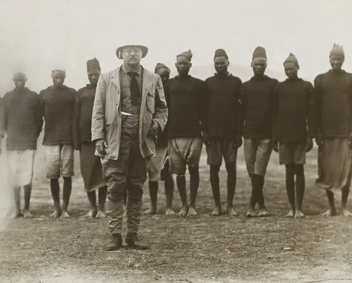 Framed Print : Theodore Roosevelt standing in front of African men working for his safari. They served as porters, cooks, on hunts, and specimen collection tasks