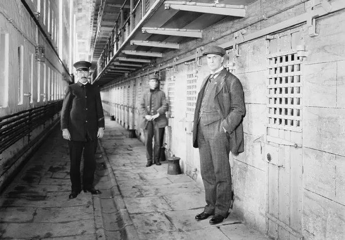 Framed Print : Thomas Mott Osborne (at right), Warden of Sing Sing prison in a cell block with guards