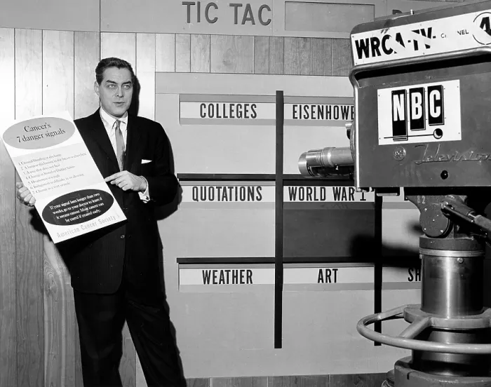 Framed Print : TIC TAC DOUGH, host Jack Barry, holding a sign listing Cancer's 7 Danger Signals provided by the American Cancer Society, on set, 1956-1959
