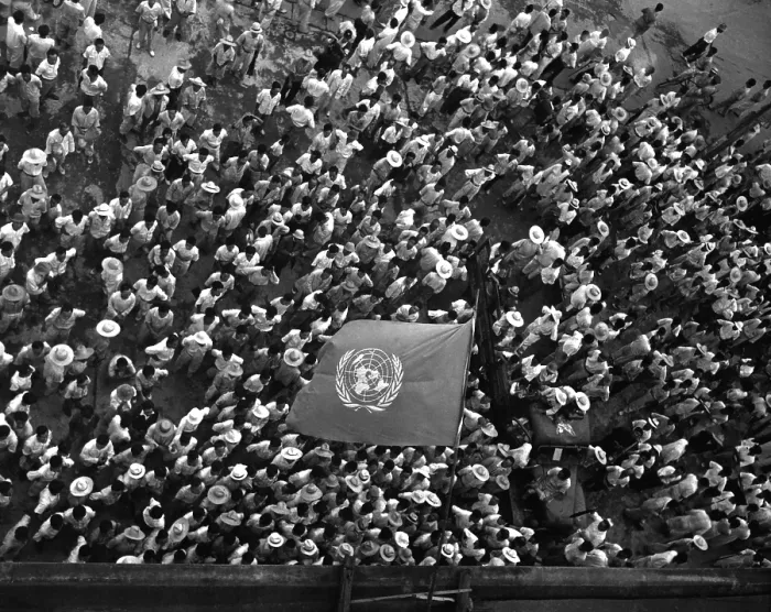 Framed Print : United Nations flag waves over crowd waiting to hear Dr. Syngman Rhee speak to the United Nations Council in Taegu, Korea