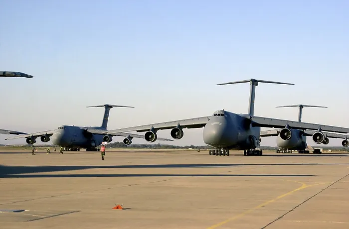 Framed Print : An U.S. airman dwarfed by a C-5 Galaxy cargo aircraft signals the plane through a crowded runway at Moron Air Base Spain Framed Print : An U.S. airman dwarfed by a C-5 Galaxy cargo aircraft signals the plane through a crowded runway at Moron Air Base Spain