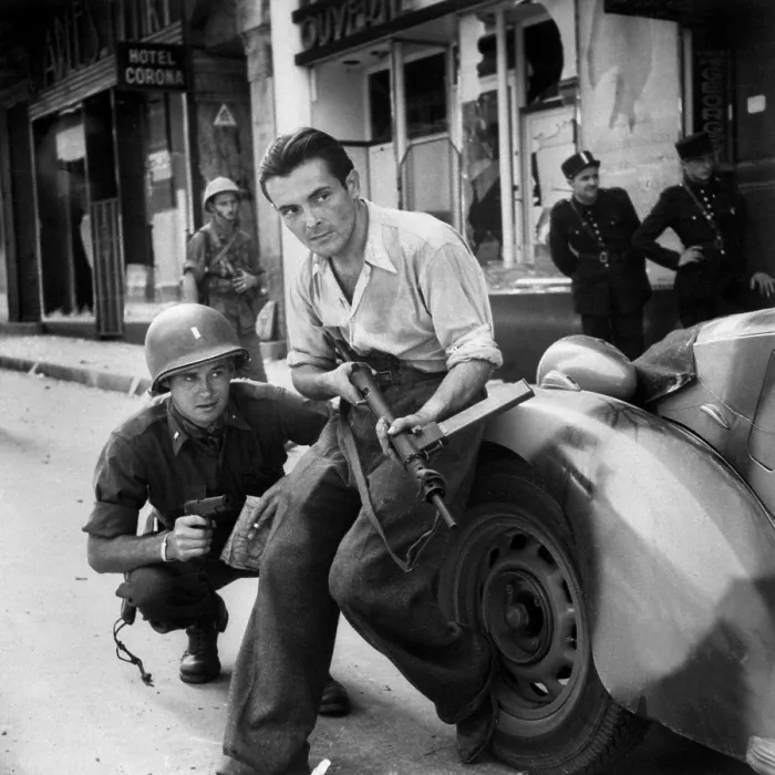 Framed Print : U.S. Army Lieutenant and French partisan crouch behind an auto in street fighting. Summer 1944. World War 2. (BSLOC_2014_2_155)