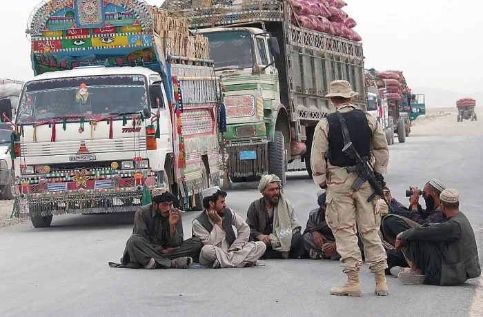 Framed Print : A U.S. Army soldier with Afghani men while they wait at a safe distance from 3 000 pounds of bombs detonated outside the perimeter of Kandahar Air Base