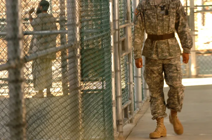 Framed Print : A U.S. Army Soldier stands guard as a detainee spends time in the exercise yard outside Camp Five at Guantanamo Bay Naval Base Framed Print : A U.S. Army Soldier stands guard as a detainee spends time in the exercise yard outside Camp Five at Guantanamo Bay Naval Base