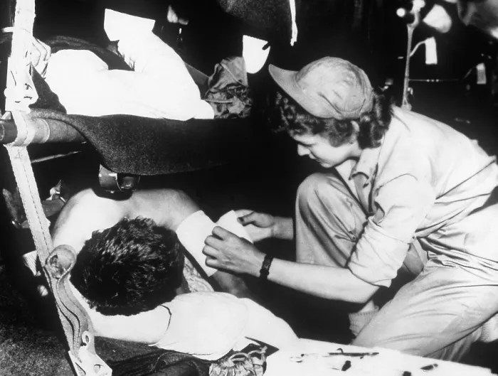 Framed Print : U.S. flight nurse dresses a soldier's wound during the flight from Korea to Japan, May 1951. Korean War, 1950-53. (BSLOC_2014_11_202)