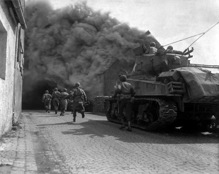 Framed Print : U.S. infantrymen running through the smoke-filled streets of Wernberg, Germany. 55th Armored Infantry Battalion and tank of the 22nd Tank Battalion. April 22, 1945. World War 2