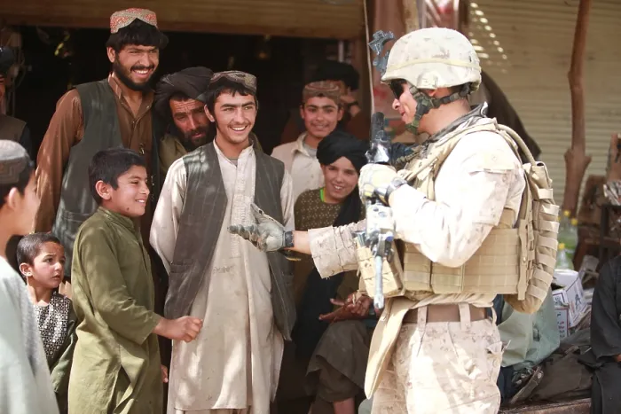 Framed Print : A U.S. Marine talks with Afghans in the Salaam Bazaar during to gather intelligence about seeking Taliban hideouts and bomb-making facilities around Now Zad Afghanistan