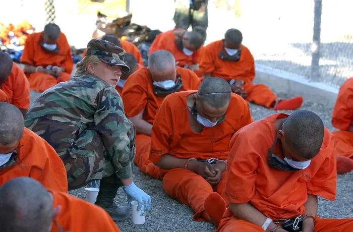 Framed Print : U.S. Military Police woman provides water to chained detainees as they arrive at Camp X-Ray at Guantanamo Bay Naval Base. The prisoners were believed by the U.S Framed Print : U.S. Military Police woman provides water to chained detainees as they arrive at Camp X-Ray at Guantanamo Bay Naval Base. The prisoners were believed by the U.S