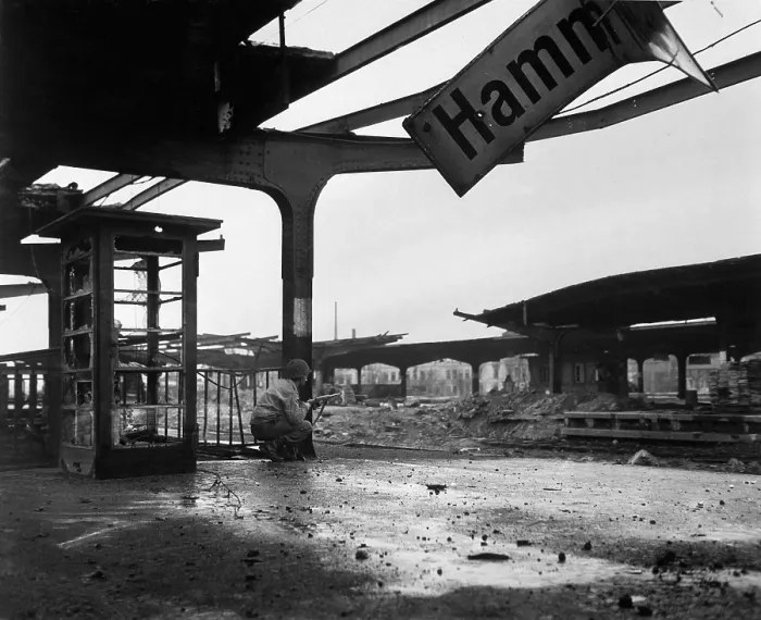 Framed Print : U.S. soldier crouches at the railroad station in the newly captured town of Hamm, Germany. April 6, 1945. World War 2. (BSLOC_2014_8_74)
