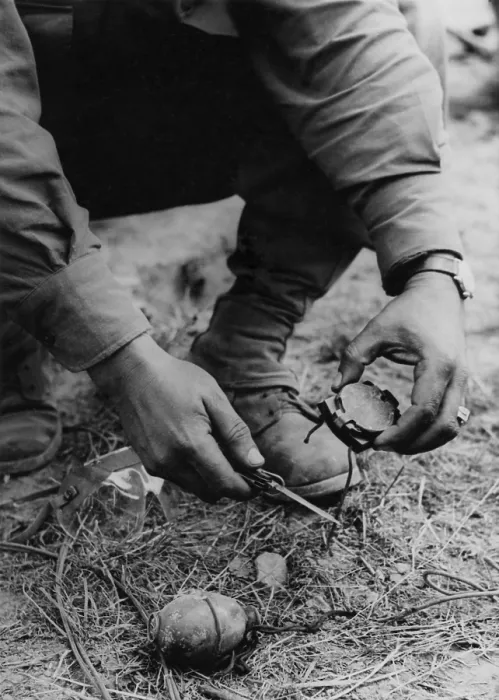 Framed Print : U.S. soldier dismantles a German booby trap planted on the road to St. Gilles. The device consisted of a tempting compass attached to a grenade with a shoestring