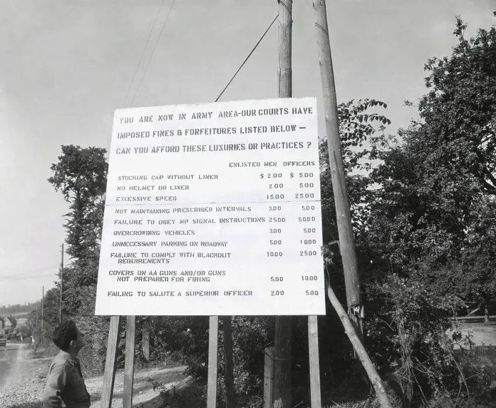 Framed Print : U.S. soldier reads table of crimes and fines for misconduct in Normandy