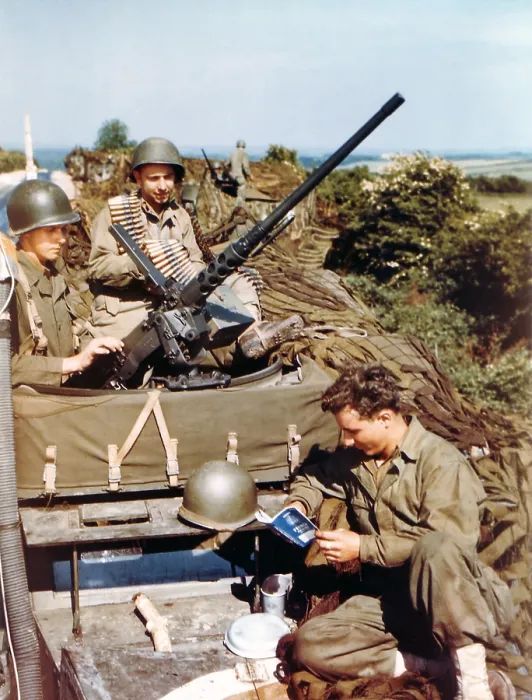 Framed Print : Three U.S. soldiers in their half-track equipped with a machine gun before the D-Day invasion. One soldiers is reading a small French textbook published for the invaders. Ca