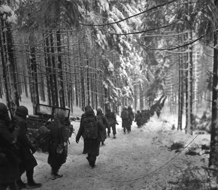 Framed Print : U.S. soldiers march along the snow-covered road in the Battle of the Bulge. They were advancing to block retreating German army by cutting off the St