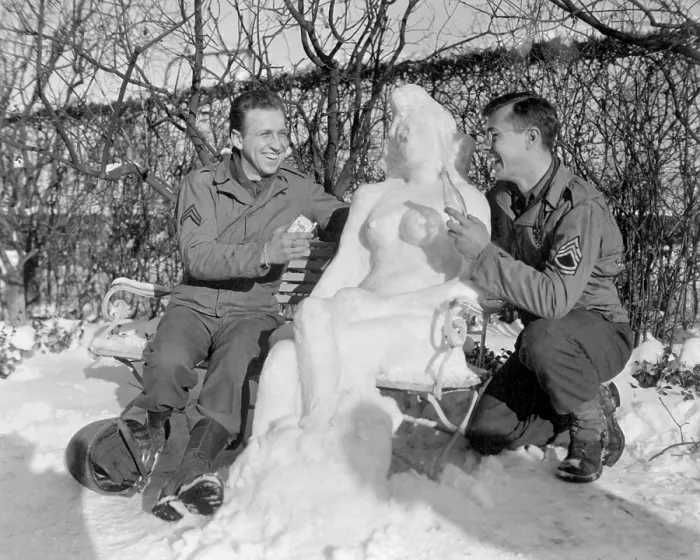 Framed Print : Two U.S. soldiers offer Agnes their snow woman, Camel cigarettes and a Coke. European theater. Jan. 14, 1945. World War 2. (BSLOC_2014_8_101)