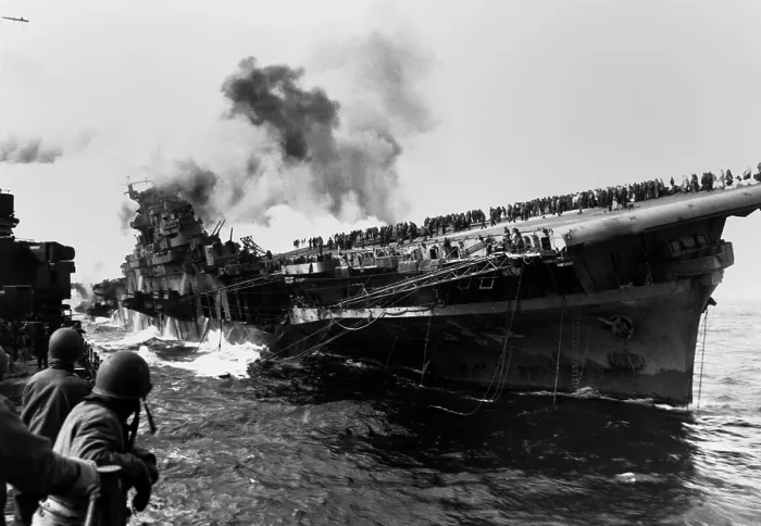 Framed Print : USS Franklin aircraft carrier on fire and listing after a strike by a Japanese dive bomber. USS Santa Fe (at left) assists the crippled carrier, that suffered 800 crewmen killed