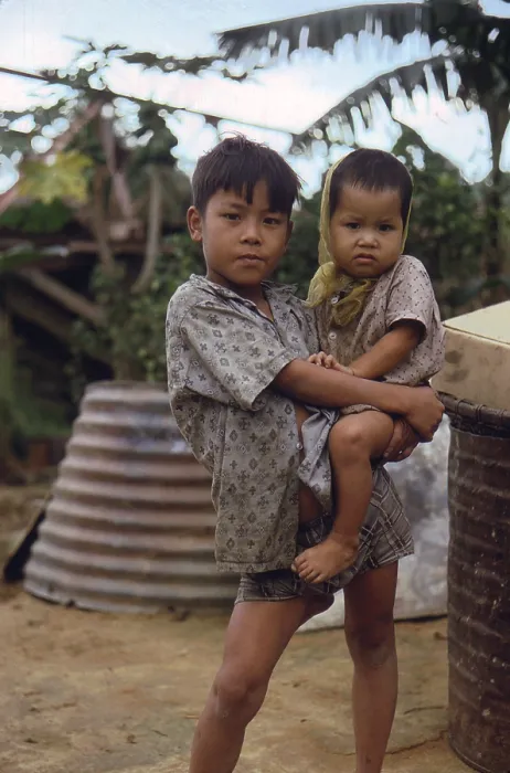 Framed Print : Vietnam War, Camp Campbell, Phu Bai, Republic of Vietnam. A Vietnamese boy carries a young child, circa late 1960s