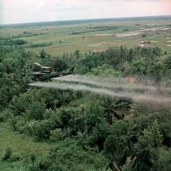 Framed Print : Vietnam War, Defoliation Mission, a UH-1D helicopter from the 336th Aviation Company sprays a agent orange on a dense jungle area in the Mekong delta, circa late 1960s