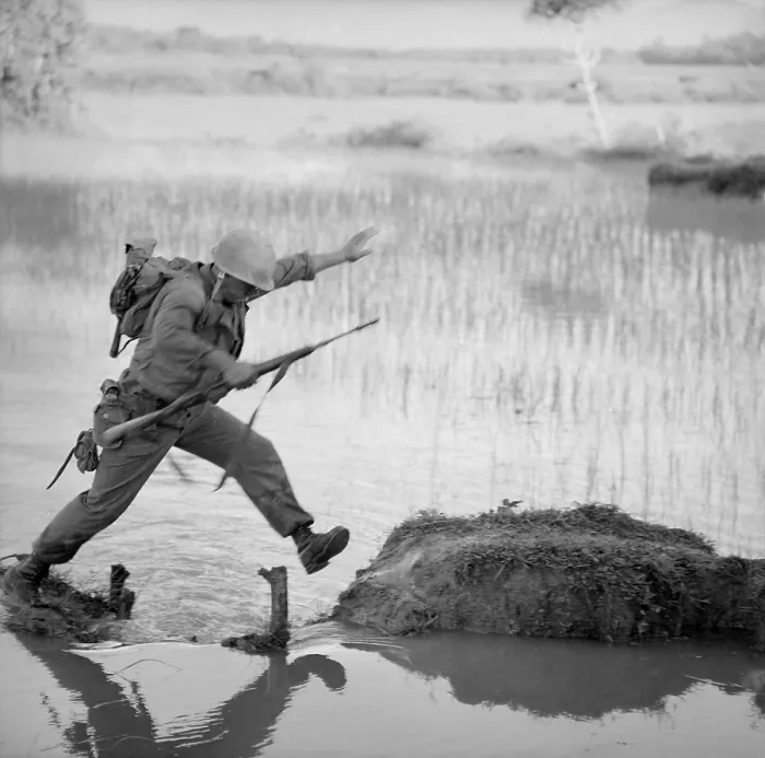 Framed Print : Vietnam War. A US Marine rifleman leaps across a break in a rice paddy dike during a search and destroy mission of Operation Colorado. Aug. 15, 1966