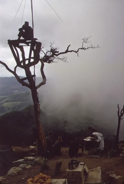 Framed Print : Vietnam War. US Marine stands watch in an observation tower as a Marine chaplain holds mass on Hill 950. Hill 950 was one of four hills surrounding the Khe Sahn Combat base