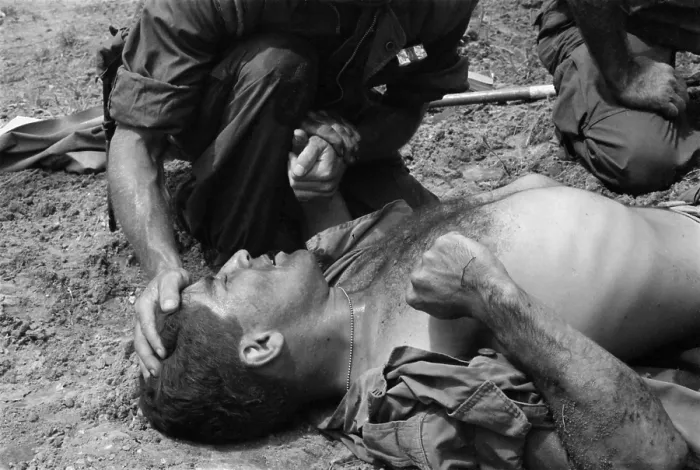 Framed Print : Vietnam War. US Marine wounded by a Viet Cong booby trap is comforted by a fellow Marine. 1967