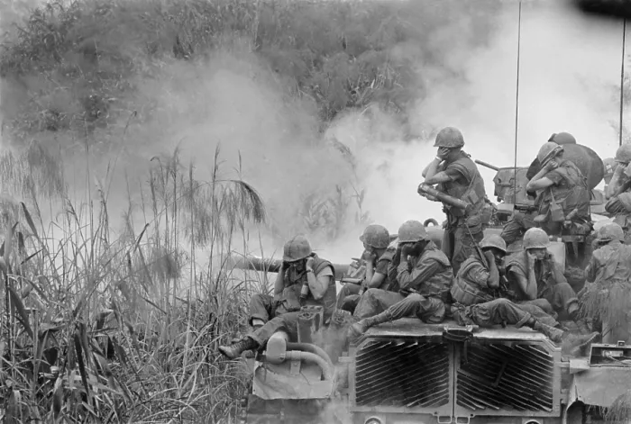 Framed Print : Vietnam War. Marines riding atop an M-48 tank cover their ears as the 90mm gun fires southwest of Phu Bai. April 5, 1968