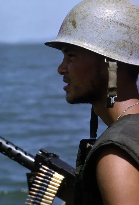Framed Print : Vietnam War, a Navy gunner mans his 50 caliber machine gun on utility boat as it cruises in the Rung Sat zone of South Vietnam during Operation Jackstay, circa late 1960s