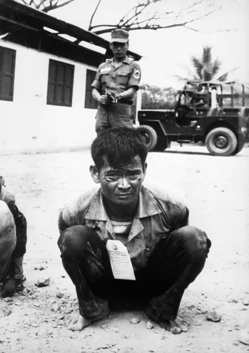 Framed Print : Vietnam War, Viet Cong, heavily guarded, awaits interrogation following capture in the attacks on the capital city during the festive Tet holiday period, circa late 1960s