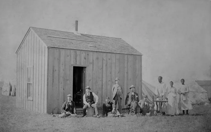Framed Print : W. H. McCoys claim, at Perry, Oklahoma, Territory, Oct. 1, 1893. A group of six men, including a soldier, pose in front of a lumber cabin, with tents in the background