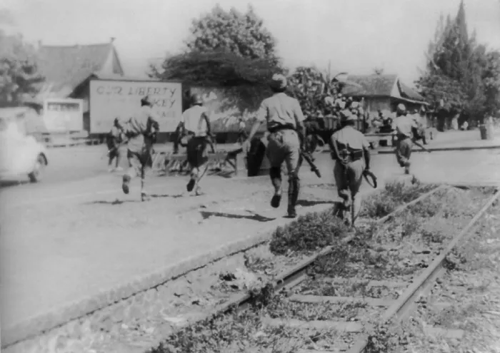 Framed Print : War for Indonesian independence began in 1945. Soldiers running down street with revolutionary billboards in the background. - (BSLOC_2014_15_175)
