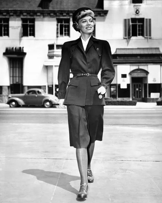 Framed Print : Wartime suit for women in defense work by Hollywood designer Irene Lentz. The suit is made of olive drab wool, with dyed cotton stockings to match. Sept. 1, 1942